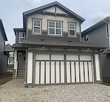 Recently built front garage home with landscaping and backyard.